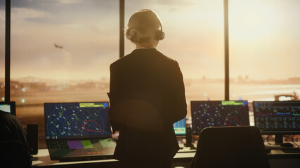 Wall Mural - Female Air Traffic Controller with Headset Talk on a Call in Airport Tower. Office Room is Full of Desktop Computer Displays with Navigation Screens, Airplane Flight Radar Data for the Team.