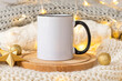 White ceramic coffee cup with black handle mockup on a golden xmas decorations background. Copy space for your design. Front view 11oz cup for Christmas promotional or souvenir imprint design