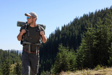 Wall Mural - Tourist with backpack in mountains on sunny day. Space for text