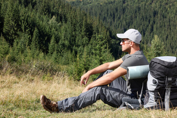 Canvas Print - Tourist with backpack in mountains on sunny day. Space for text