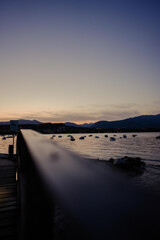 Canvas Print - Vertical shot of the beautiful sunset over the Lake Garda with boats