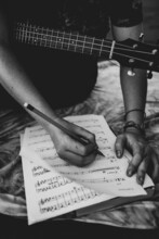 Guitarist Taking Notes In Music Sheet
