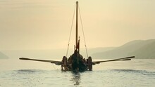 Vikings Sail On An Old Ship With A Lowered Sail On A Quiet River In The Fog. Concept On The Theme Of The Vikings And The Early Middle Ages.