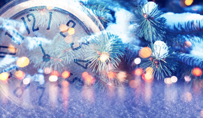 Wall Mural - New Year's holiday background. Vintage clock close-up on the background of blurred lights, fir branches with Christmas toys.