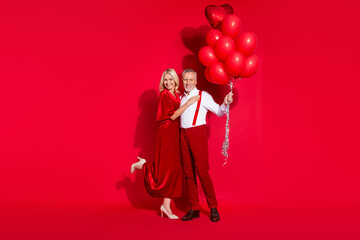 Wall Mural - Full size photo of retired girlfriend boyfriend romantic cuddle feelings many air balls suspenders isolated over red color background