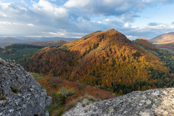 Poster - Scenic landscape in Sulov, Slovakia, on beautiful autumn sunrise with colorful leaves on trees in forest and bizarre pointy rocks on mountains and slight mist in the valleys and dramatic clouds on sky