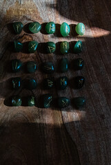 Viking ancient rune stones carved on gemstones.
Rune stone on a wooden table.