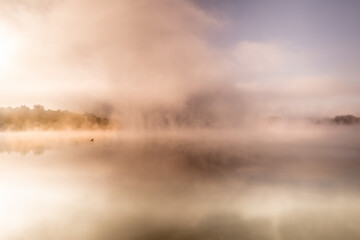 Morning fog over the lake. Autumn morning by the water.