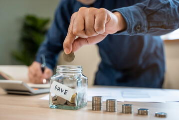 the person putting coin into piggy bank to save money and invest for growth in future.