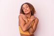 Young latin transsexual woman isolated on pink background hugs, smiling carefree and happy.