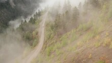 Aerial Panorama View Of The Breathtaking Mountainous Landscape In Tweedsmuir (South) Provincial Park In A Dense Fog That Is Covering The Surrounding Mountains, The Valley And The Road To Bella Coola