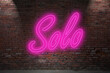 Neon group Solo sex lettering on Brick Wall at night