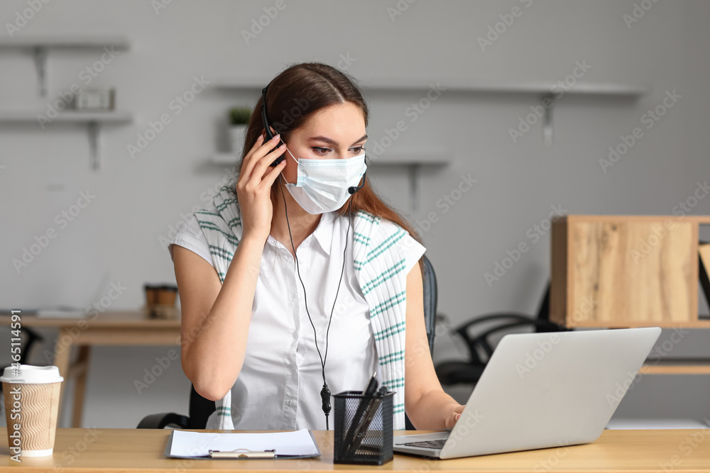 Technical support agent in medical mask working in office