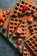 Board Of Delicious Chocolate Belgian Waffles With Strawberry On Black Background, Closeup