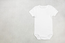 White Baby Girl Or Boy Bodysuit Mockup Flat Lay On The Gray Concrete Background. Design Onesie Template, Print Presentation Mock Up. Top View.
