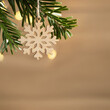 Zero waste and eco friendly christmas concept. Wooden snowflake on a Christmas tree branch on background of wooden wall. Horizontal banner, copy space