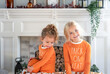 Two cute little girls in matching Halloween pajamas