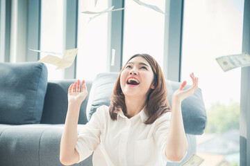 Happy young asian woman holding dollar money and throw in the air celebrate happiness dance wealth lottery money rain drop. Winner Success business woman throw cash flow Happy money smiling face