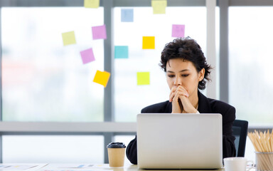 Caucasian businesswoman contemplate difficult problem and consider solution idea from strategy analysis at laptop after brainstorming by sticky paper notes in conference room of company office