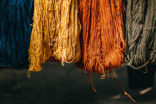 Multi Colored Threads Hanging On Bamboo. Hanging Skeins Of Yarn Background.