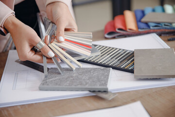 Closeup hand of Woman interior designer chooses grout color for ceramic tiles