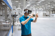 © Westend61 - Male professional gesturing while using virtual reality headset in factory