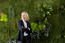 Mature Female Professional Standing With Arms Crossed In Front Of Plants