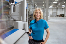 Female Professional Smiling While Holding Digital Tablet By Machinery
