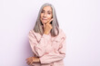 middle age gray hair woman looking serious, thoughtful and distrustful, with one arm crossed and hand on chin, weighting options