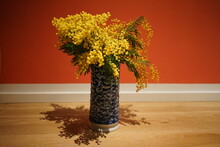 Close-up Of Vase On Table Against Orange Wall