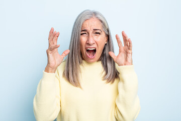 Wall Mural - middle age gray hair woman furiously screaming, feeling stressed and annoyed with hands up in the air saying why me