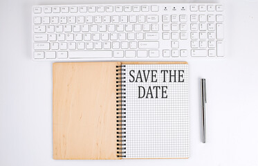 Wall Mural - SAVE THE DATE text on the notebook with keyboard on white background