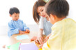 © maroke - 幼稚園で折り紙をする子どもと先生