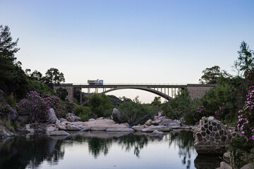 RIVER UNDER THE BRIDGE WITH BEAUTIFUL TREES AND ROCKS