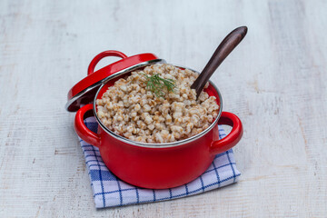 Tasty buckwheat porridge in a red saucepan