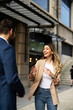 © JustLife - Young businesswoman and businessman standing on the street Beautiful businesswoman talking with her colleague.