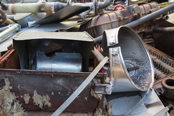 Special waste or valuable resources: Old rusty components of a heating boiler as pipes, counters, electric parts or control elements ready for removal or metal, cast iron and aluminium recycling