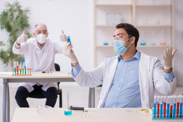 Two male chemists working at the lab during pandemic