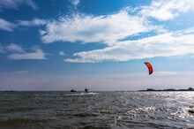 A Kite Surfer Sailing At Sea. Storm Waves And Windsurfing. Surfer On The Sea