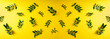 © missmimimina - Pistachio branch with green leaves on yellow background. Green leaves pattern. Top view, flat lay