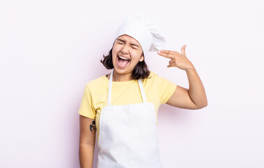 Wall Mural - pretty young woman looking unhappy and stressed, suicide gesture making gun sign. chef concept