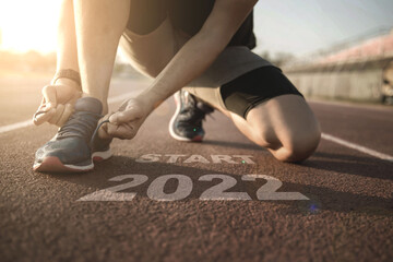 happy new year 2022,2022 symbolises the start into the new year.Start of people running on street,with sunset light.Goal of Success	