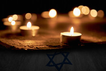 Candles Burning Over The Star Of David In Memory Of The Dead. A Symbol Of Remembrance Of The Victims Of The Genocide Of The Jew