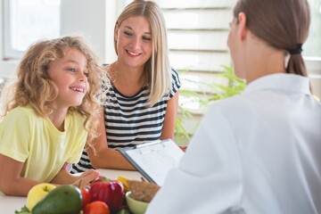 Canvas Print - Worried mother and little boy during a visit to a dietitian preparing a healthy diet plan