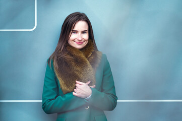 portrait of an elegantly dressed business woman near a blue wall of a modern office building