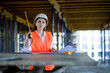 © volody10 - Architect or engineer working, browsing building project indoor of construction site with blueprint plan. Woman construction engineers or architects working people