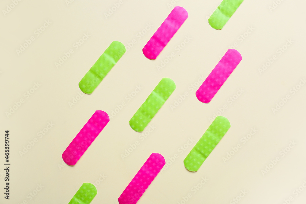 Different medical plasters on color background