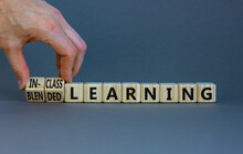 Blended Or In-class Learning Symbol. Businessman Turns Cubes, Changes Words Blended Learning To In-class Learning. Grey Background. Education And Blended Or In-class Learning Concept. Copy Space.