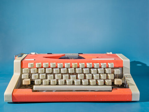 Red typewriter on blue background