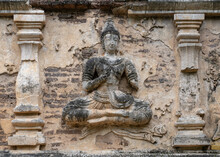 Beautiful Ancient Stucco Life Size Carving Of Sitting Deity On Wall Of Wat Chet Yot Or Wat Jed Yod Buddhist Temple, Historic Landmark Of Chiang Mai, Thailand
